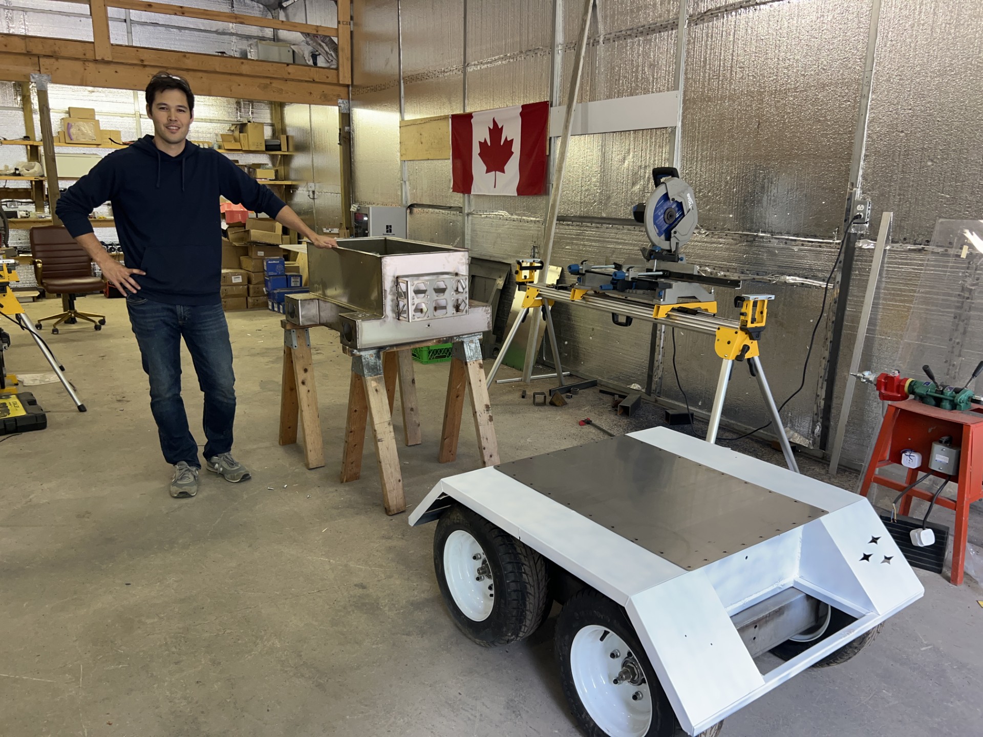 Shaun Riddell, Founder & CEO of SpaceDIRT, with an early SLED rover prototype in the workshop